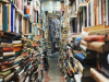 Looking down a narrow path with walls crammed with books looming in from both sides