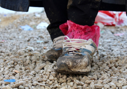 A refugee’s shoes are worn, wet, and muddy after a long journey. These shoes are owned by Ali, a Yazidi refugee who traveled from Iraq to Preševo, Serbia, to avoid persecution (photo by Meabh Smith / Trócaire).